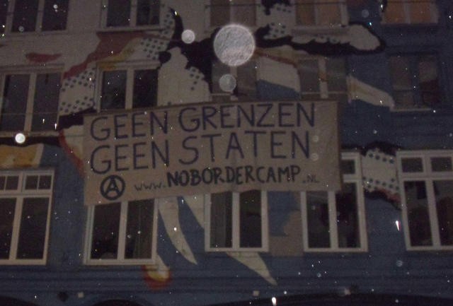 Ook in Amsterdam hangt een spandoek ter aankondiging van het No Border Camp